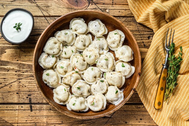 Albóndigas rusas caseras Pelmeni con carne de res y cerdo en un recipiente de madera