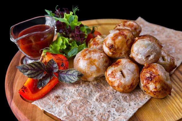 Albóndigas con salsa y hierbas sobre una tabla de madera