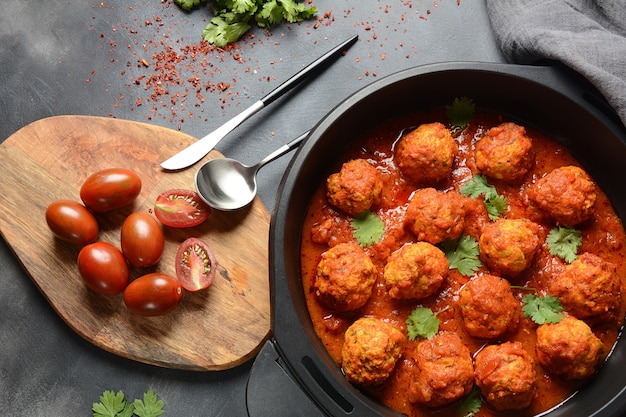 Albóndigas en salsa de tomate agridulce con especias servidas en una sartén