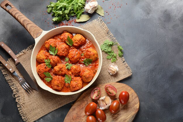 Albóndigas en salsa de tomate agridulce con especias servidas en una sartén