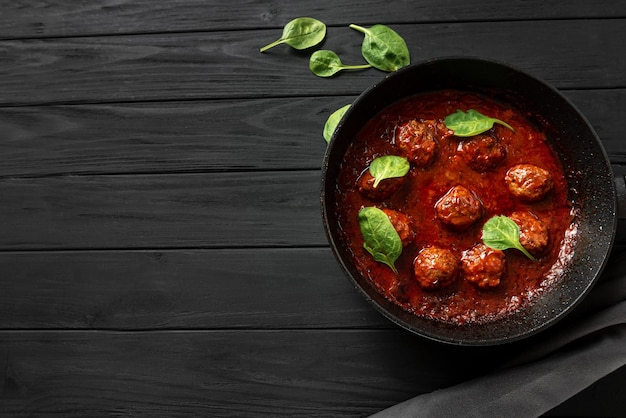 Albóndigas en salsa de tomate con espacio de copia de albahaca para el texto