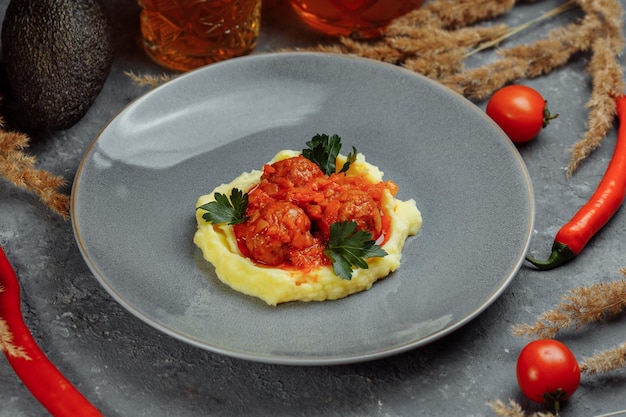 Albóndigas en salsa de tomate con puré de patata en la vista superior del plato blanco desde arriba