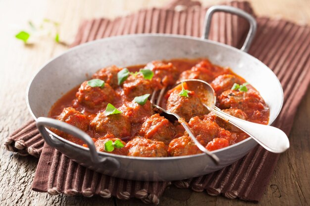 Albóndigas con salsa de tomate en sartén con cuchara