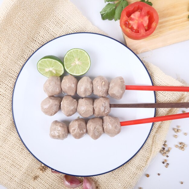 Albóndigas satay sobre fondo blanco