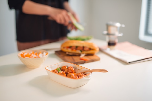 Albóndigas servidas con salsa de tomate como sándwich, desayuno vietnamita