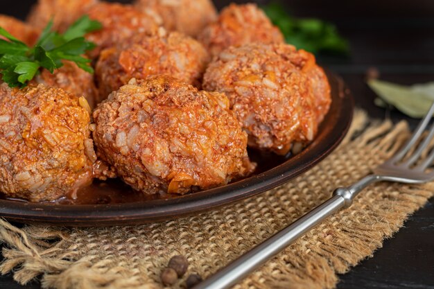 Albóndigas sobre un fondo de madera con hojas de salvia y perejil. Almuerzo casero.