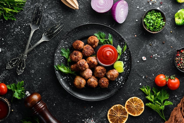 Albóndigas de ternera al horno con ketchup en un plato negro Vista superior Espacio libre para el texto