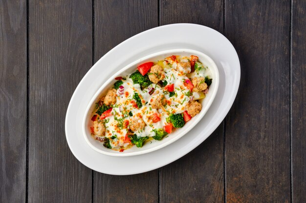 albóndigas de ternera con tomate cerca de brócoli y pimiento y queso al horno