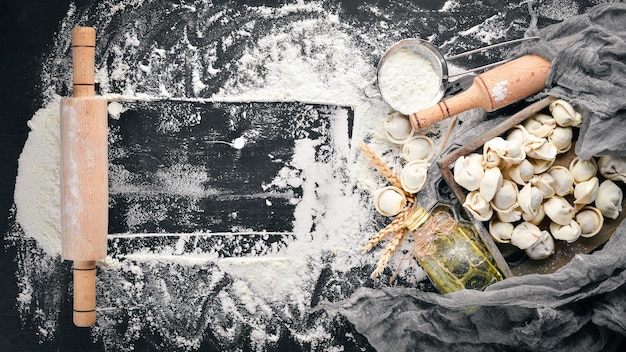 Albóndigas tradicionales rusas de pelmeni ravioli con carne sobre fondo de hormigón negro Vista superior Copyspace