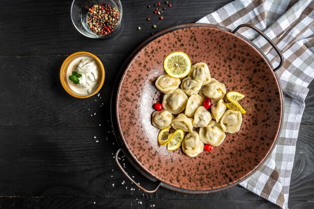 Albóndigas tradicionales rusas de pelmeni ravioli con carne sobre fondo de madera negra banner menú de catering receta lugar para la vista superior de texto