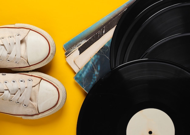 Foto Álbumes de discos de vinilo y zapatillas retro en amarillo