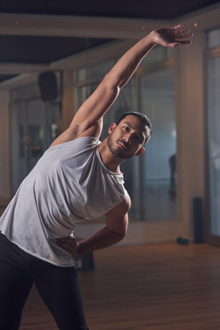 Foto alcançando seus objetivos de fitness foto recortada de um belo jovem atleta masculino passando por sua rotina de aquecimento no ginásio
