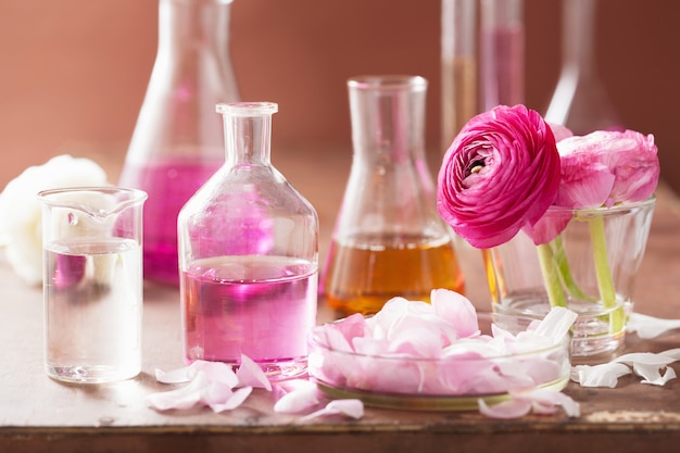 Alchemie und Aromatherapie mit Ranunkelblüten und Flaschen