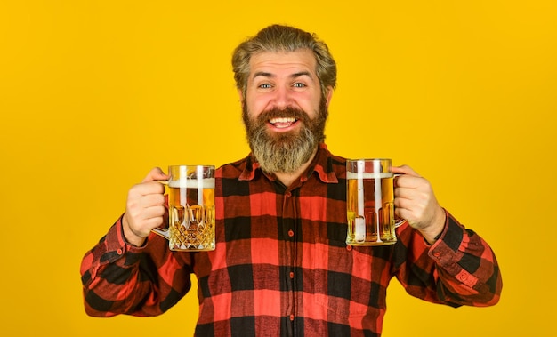 Alcoólico. Homem sedento bebendo cerveja no bar. Cerveja com espuma. Hipster bebe cerveja. Cara barbudo maduro segura copo de cerveja. Saudades do brinde. Celebração do feriado. Dia dos Pais. Conceito de festa de aniversário.