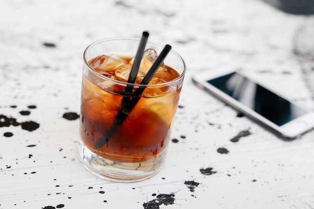 Alcoolismo, alcoolismo e conceito de pessoas - feche com um copo de uísque e smartphone na mesa