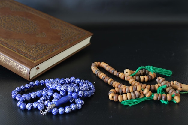 alcorão e tasbih em fundo preto. Oração e foto temática religiosa islâmica.