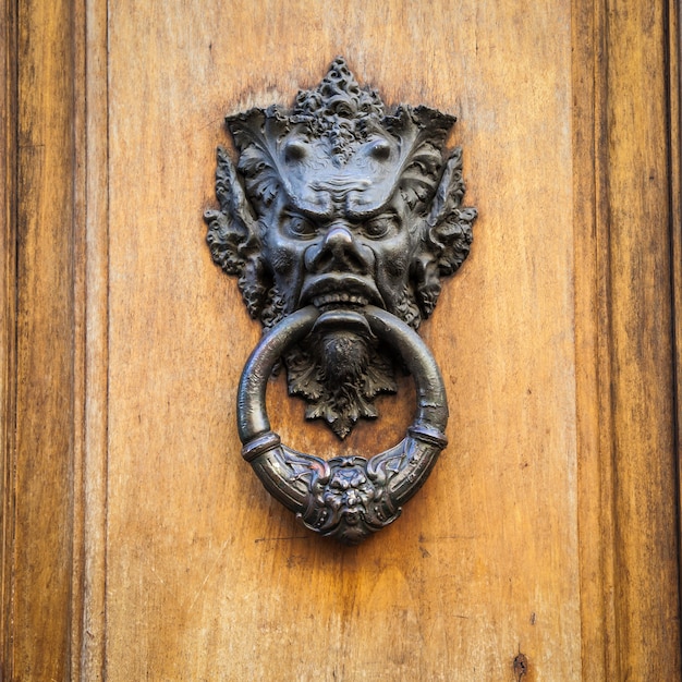 Foto aldaba en una antigua puerta de madera en toscana - italia