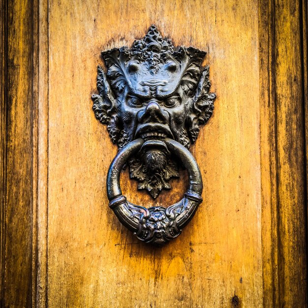 Foto aldaba en una antigua puerta de madera en toscana - italia