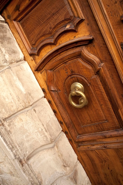 Aldaba con estilo en una puerta de madera en un pueblo francés