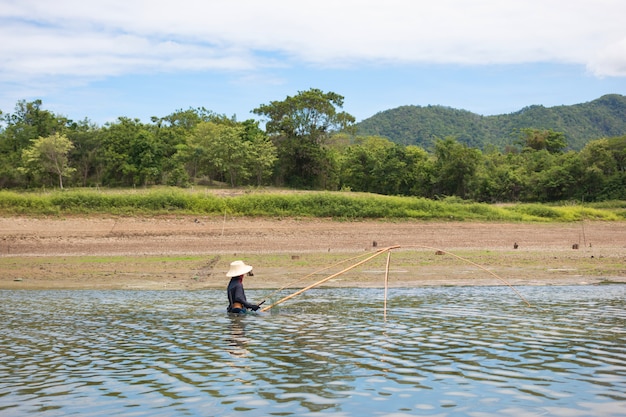 Los aldeanos están buscando peces en tierra con tierra seca y agrietada debido a la sequedad del calentamiento global.