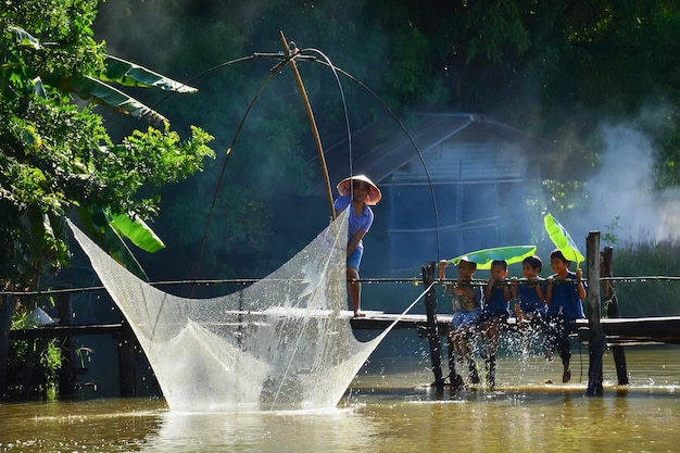 Los aldeanos y los niños practican la pesca tradicional tailandesa en el río. En Chiang Mai, Tailandia 05/12/2021