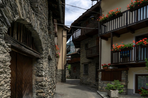 Aldeia antiga com rua estreita de paralelepípedos e casas feitas de pedra e madeira