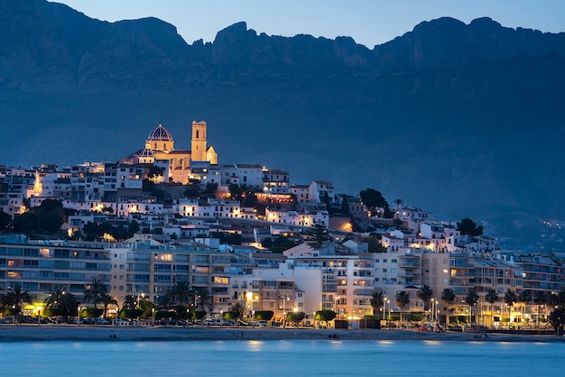 Aldeia com igreja iluminada e montanha