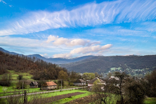 Aldeia da montanha em um dia ensolarado de verão Vista incrível em uma pequena aldeia no vale verde das montanhas com campos e aldeias entre montanhas