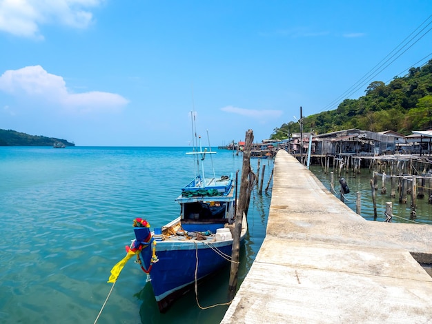 Aldeia de Ao Yai Koh kood trat Tailândia Cena de barco de madeira perto da ponte e vila de pescadores no mar azul e montanha verde com bela vista com céu aberto no dia de sol de verão