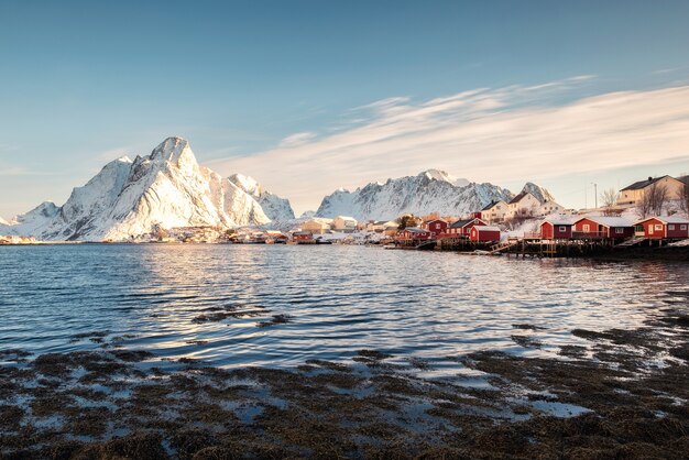 Aldeia de pescadores escandinavos com montanhas nevadas no litoral. Reine, ilhas Lofoten, Noruega