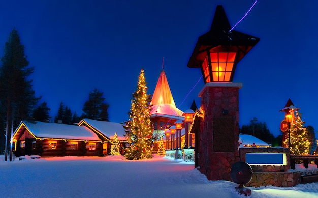 Aldeia do Papai Noel em Rovaniemi da Finlândia Lapônia. Inverno de casa de escritório de Natal. Laponia e neve. Viaje para Joulupukki no parque de férias no pólo norte. Ano Novo. Poste com luzes. Decoração de árvore