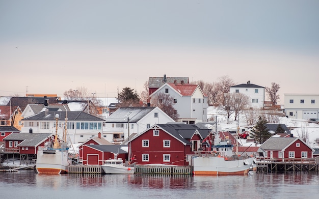 Aldeia norueguesa com barco de pesca no litoral no inverno