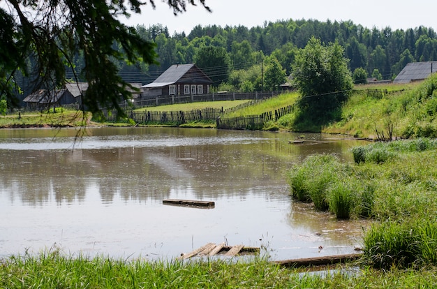 Aldeia russa na margem da lagoa. rússia, os urais. soma