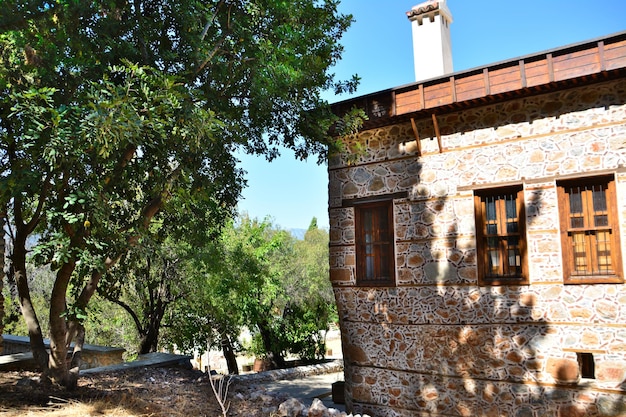 aldeia turca tradicional com casa de tijolos com tubo na sombra da árvore