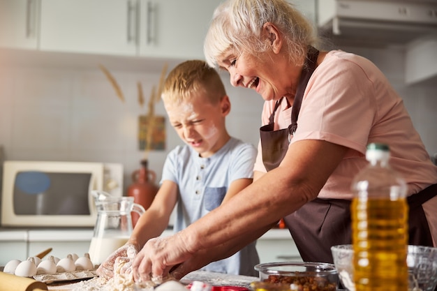 Foto alegre anciana y su nieto cocinando juntos