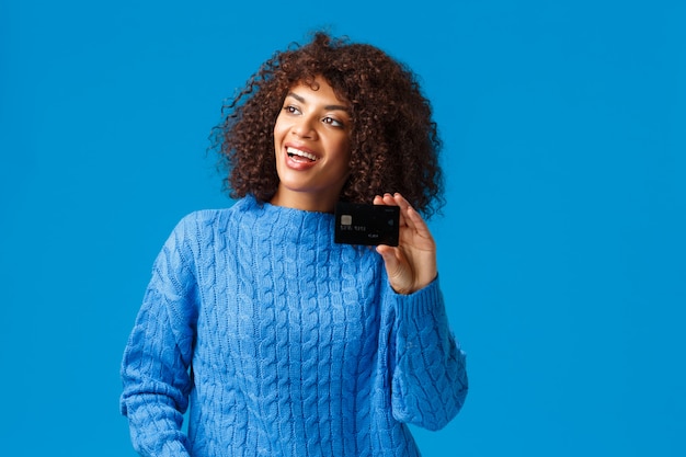 Alegre atractiva mujer afroamericana con corte de pelo afro, suéter de invierno