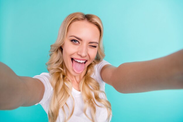 alegre bastante rubia blogger dama hacer selfie mostrar lengua