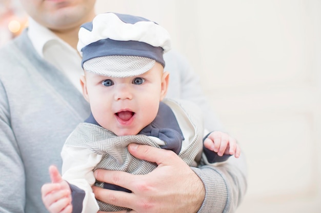 Foto alegre bebé juguetón en brazos de su padre bebé y papá