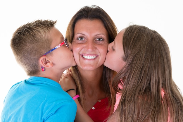 Alegre beso de la madre por hijo hija niño y niña concepto feliz amor familiar