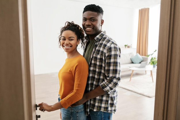 Foto alegre casal afro-americano abrindo a porta de sua casa