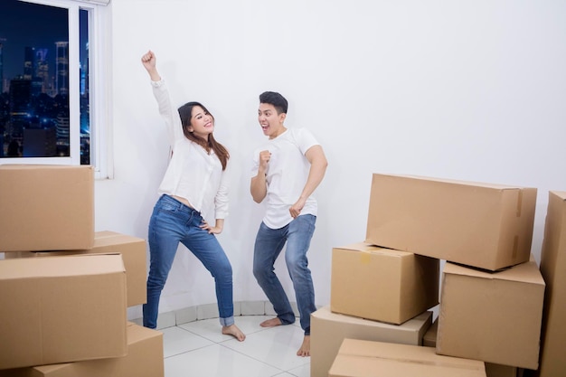 Alegre casal dançando no novo apartamento