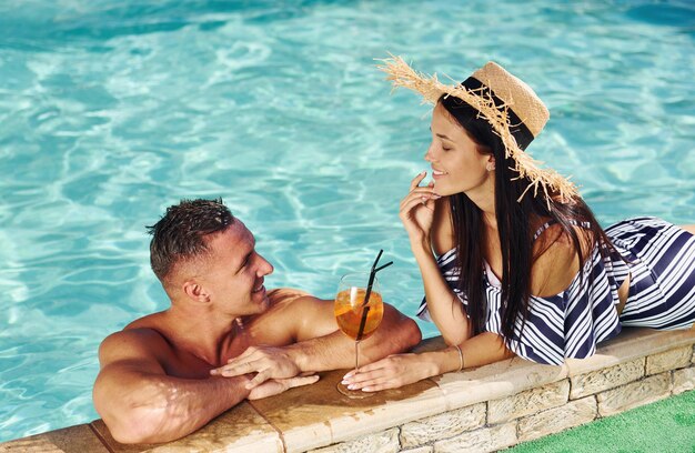 Foto alegre casal ou amigos juntos na piscina de férias