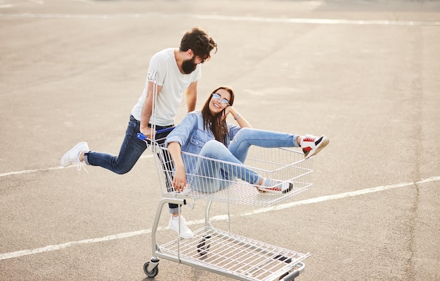 Alegre casal se divertindo com carrinho de compras