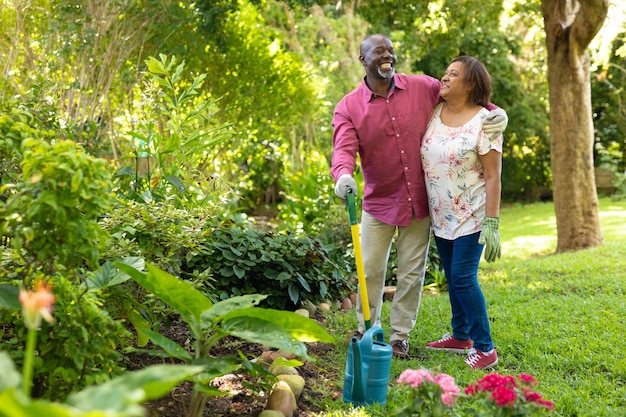 Alegre casal sênior afro-americano jardinando juntos no quintal