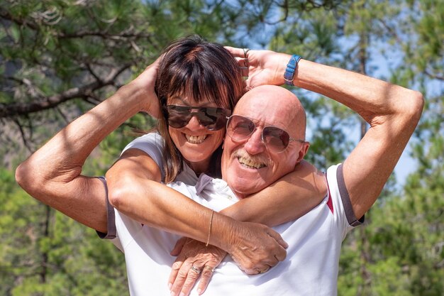 Alegre casal sênior se abraçam em uma excursão de montanha expressando felicidade e bem-estar