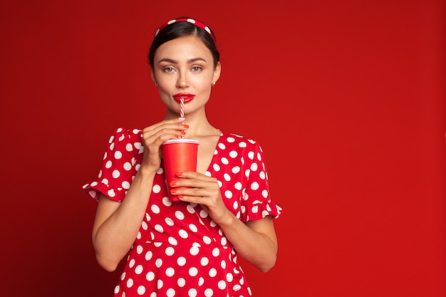 Alegre chica morena pin-up con refresco