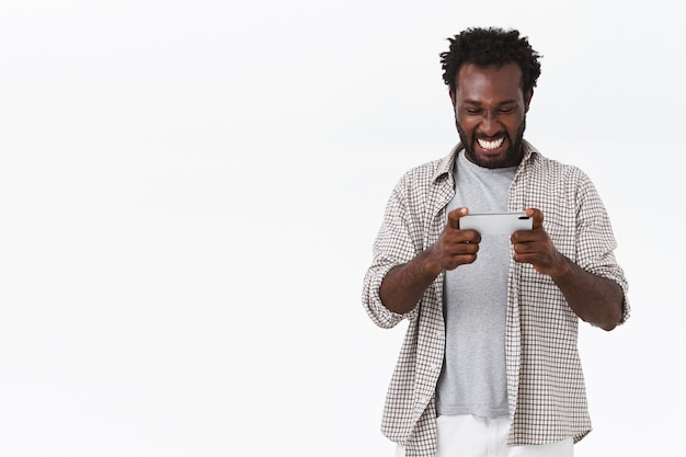 Alegre chico barbudo afroamericano jugando nuevo juego impresionante