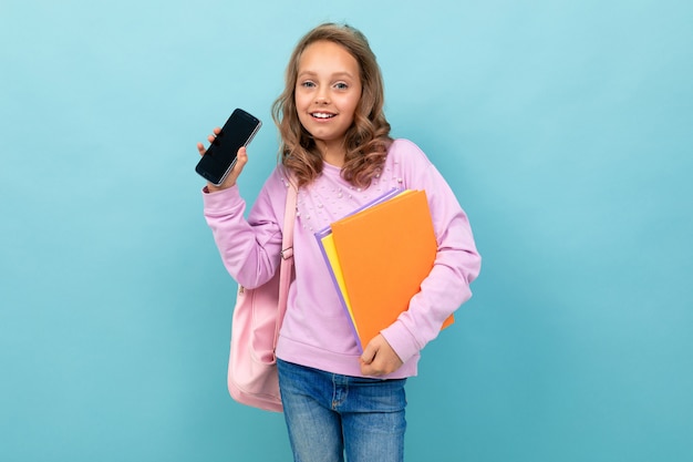 Alegre colegiala con libros en blusa púrpura sonrisas