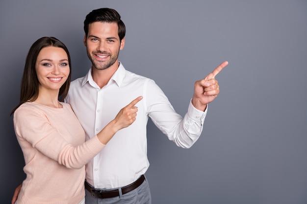 Foto alegre confiável casal homem mulher juntos indicam o espaço em branco do dedo