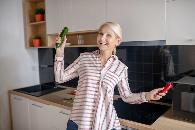 Alegre. Dona de casa loira se divertindo na cozinha e se sentindo alegre